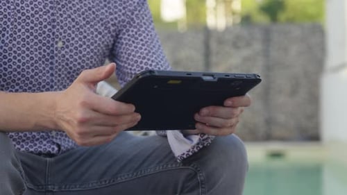 Closeup of person holding tablet with both hands, showcasing sleek modern technology