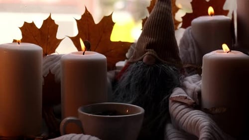 Burning Candles, Tea Cup and Gnome at Fall