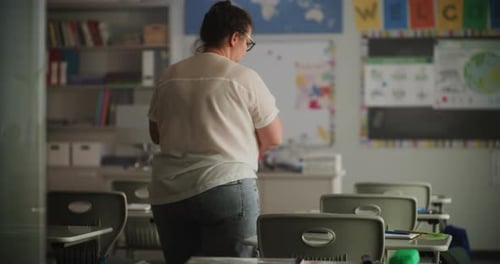 Teacher Organizes Materials in Classroom Before School