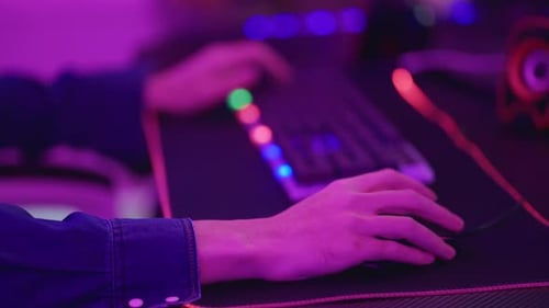 Close up of young Esport male gamer play online video game on computer.