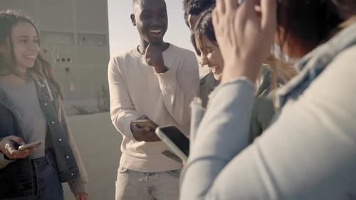 Friends Gather Outdoors Looking at Phones