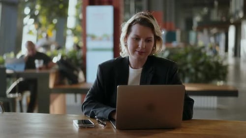 Woman Works on Laptop in Modern Office