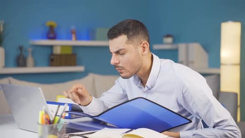 Home office worker man reviewing paperwork files.