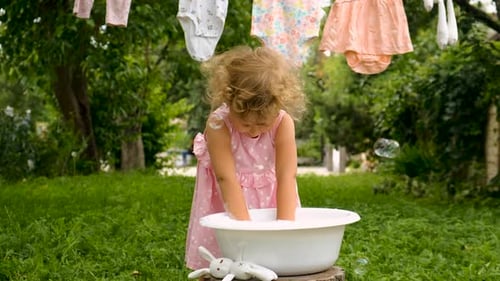 The Child is Washing Clothes in the Garden Selective Focus