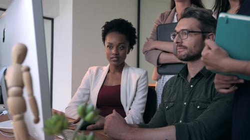 Team Collaboration: Focused Colleagues Working Together in Office