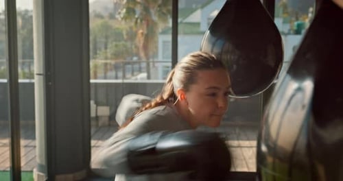 Boxer, woman and punching bag for exercise, training and workout for wellness, health and in gym