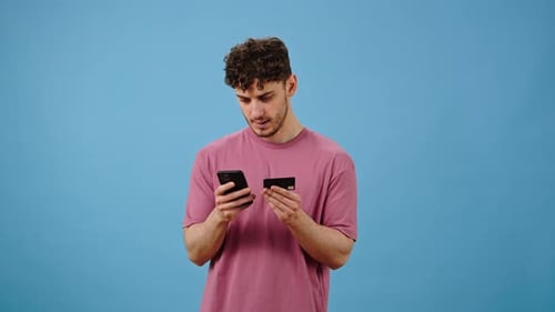 Young Man Uses Phone and Credit Card