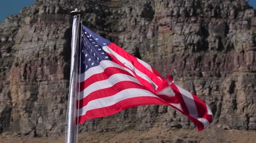 American Flag Waving Against a Rocky Mountain