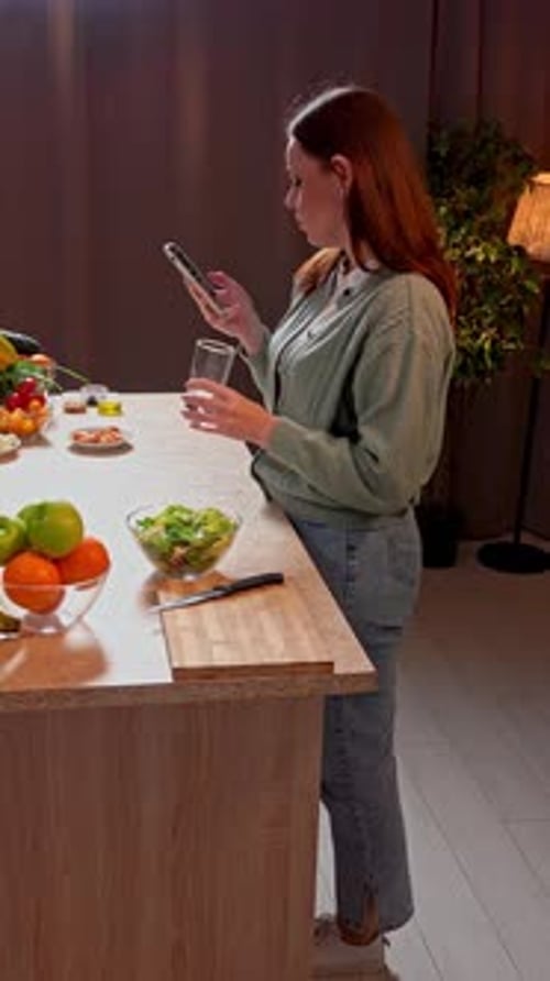 Woman Using Phone, Drinking Water in Kitchen