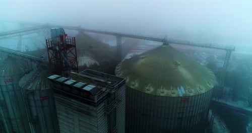 Dirty roofs of the grain elevators at agribusiness plant Drone footage of the silo elevators