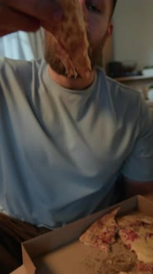 Young Man Taking Slice of Delicious Pizza Enjoying Fast Food at Home