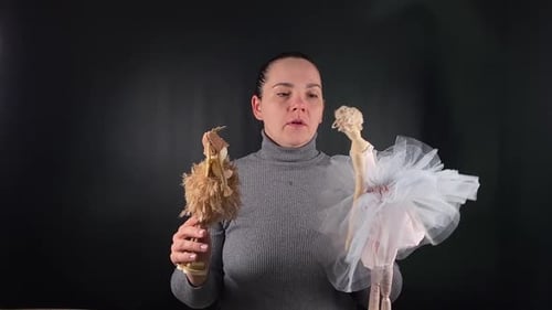 Woman Holding Two Ballerina Dolls in Studio