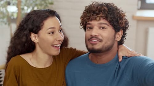 Happy young couple video calling from home