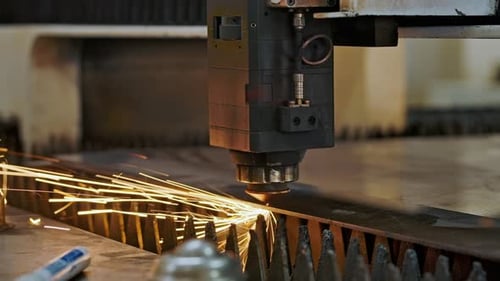 CNC-Laserschneidmaschine mit Funken zur Bearbeitung von Blechen in einer Industriefabrik