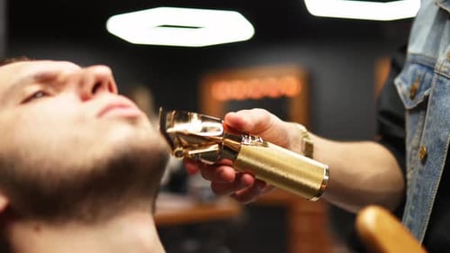 Barber Shaving Man's Beard with Electric Razor