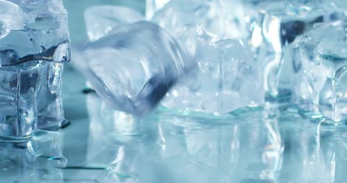 Ice Cubes Falling on Wet Reflective Surface