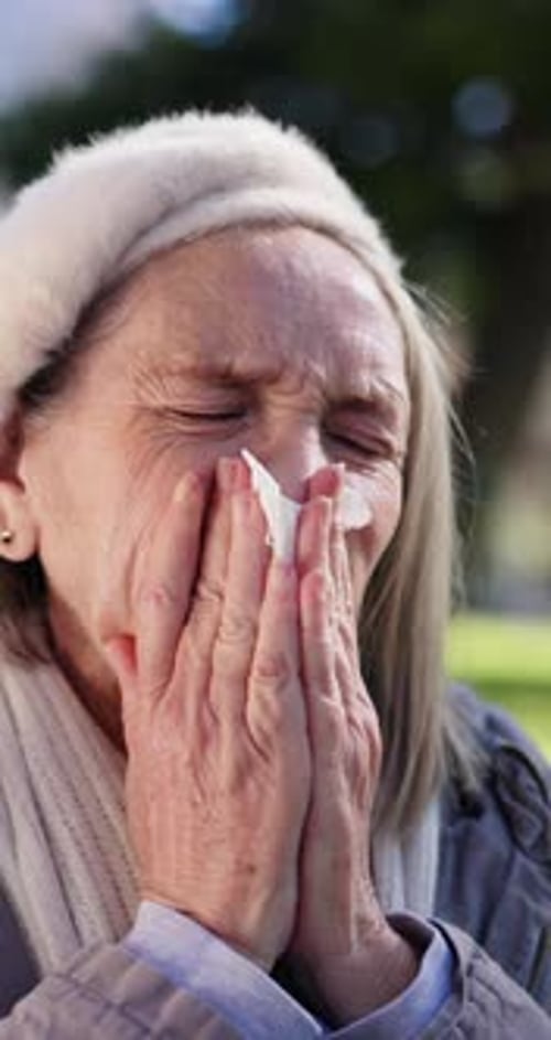 Senior Woman Outdoors Using Tissue for Cold