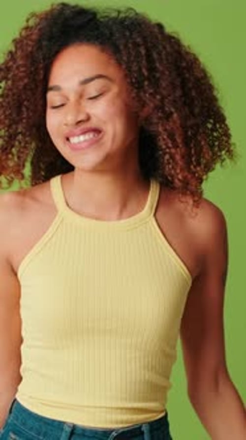 Young woman dancing on green screen background