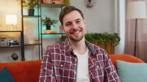 Smiling Man Sitting on Couch in Living Room