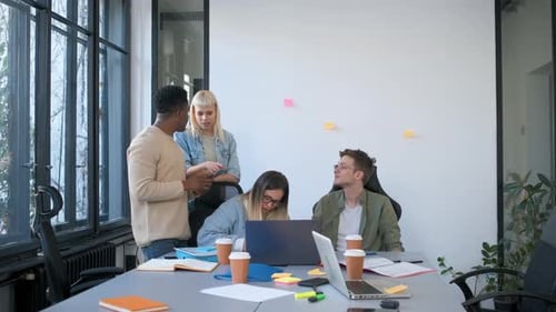 Diverse group of young business people working on new project together in office.