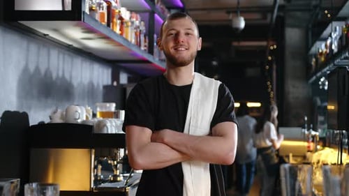 Confident Young Man Smiles in Modern Bar