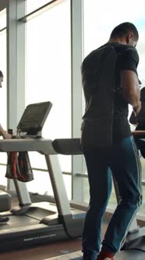 Vertical of Back View of Running on Treadmill Sporty People Indoor of Modern Gym