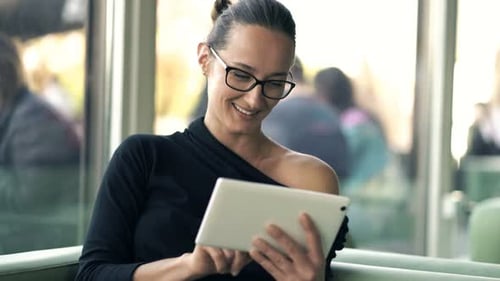 Young Woman Using Tablet Computer While Sitting in Cafe 30s