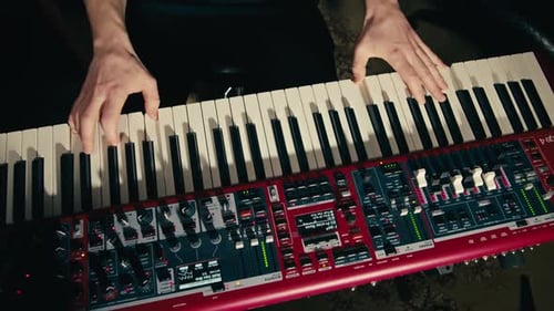 Primer plano de las manos de un teclista tocando música rock con el teclado en el concierto en el estudio