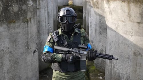 Tactical individual holding rifle in urban setting