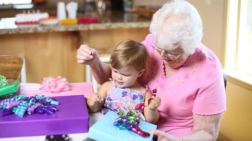 Grandmother and Grandchild Opening Presents at Birthday Party