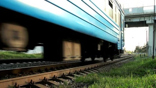 Elektrischer Hochgeschwindigkeitszug fährt unter einer Autobrücke auf Bahngleisen