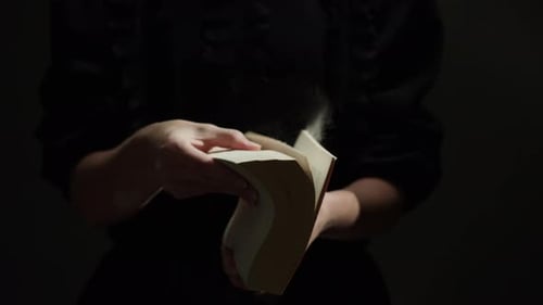 Hands Turning Pages of a Thick Book