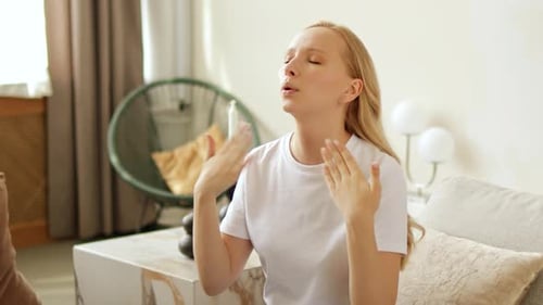 Blonde Woman Fanning Herself on Sofa