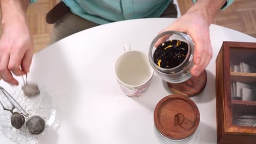 Person Preparing Tea with a Tea Infuser