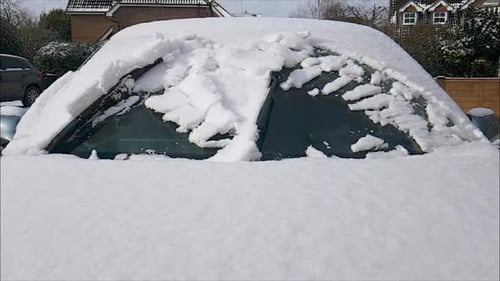 Windscreen (windshield) wipers sweeping snow from windscreen (windshield) in slow motion (0.2x speed