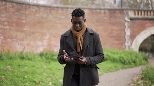 Young Man Puts on Gloves in Urban Park