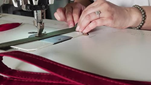 Woman's Hands Guide Fabric Through Sewing Machine