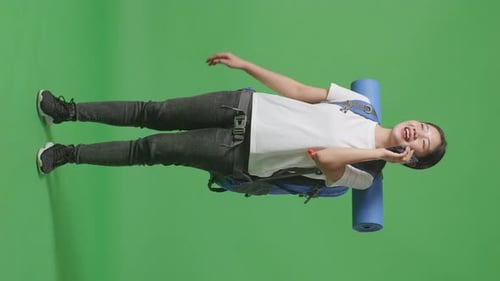 Full Body Of Asian Female Hiker Talking On Smartphone While Standing On Green Screen Background