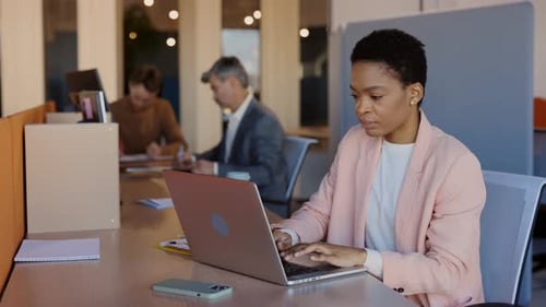 Woman Typing on Laptop in Modern Office