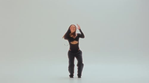 Stylish Woman Dancing in a Bright Studio