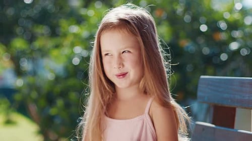 Portrait of the Caucasian Pre Teen Girl Talking and Looking Into the Camera with Green Garden on the