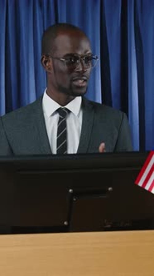 Professional Man Speaking at Podium with American Flag