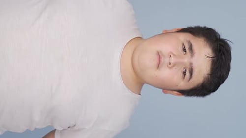 Vertical Video of Boy looking at camera with curious expression.