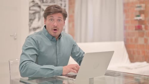 Surprised Adult Typing on Laptop at Home