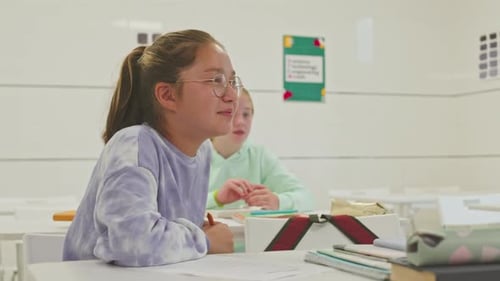 Schoolgirls Seated at Desks in Classroom Setting
