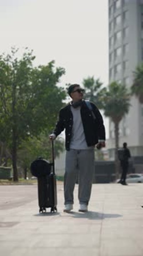 Stylish Man Walking with Luggage on City Sidewalk
