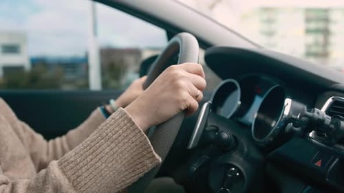 Woman Driving Car Through City Streets