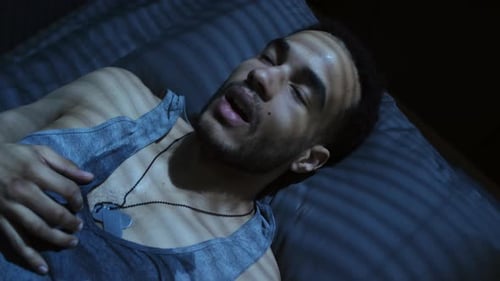 Sweaty Man Lying in Bed at Night