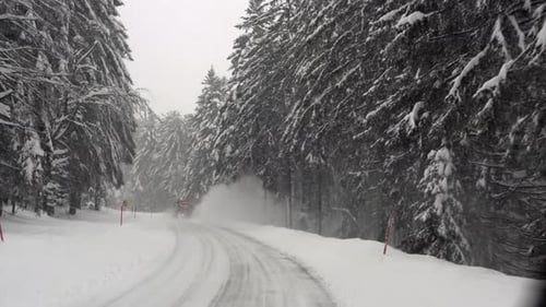 Snowplow remove snow from icy road in Germany