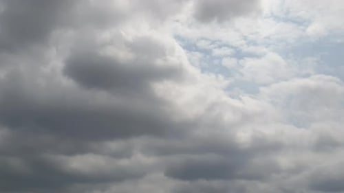Blue summer sky with dense thick thunderstorm rain clouds moving across the heavens. Fast cloud form